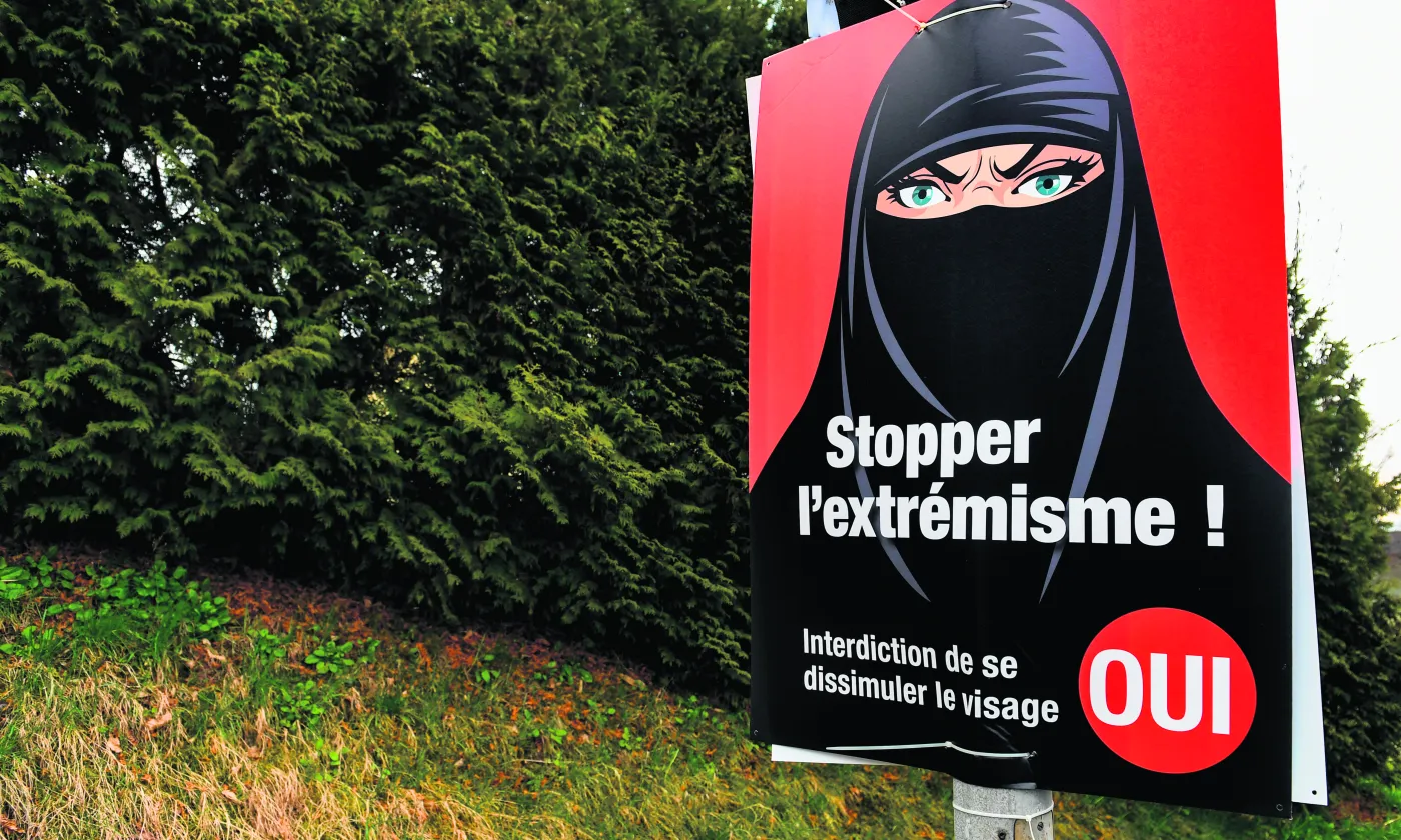 Vevey, le 7 mars 2021. Une affiche en faveur de l’interdiction de se dissimuler le visage acceptée par les électeurs suisses ce jour-là. Si le type de vêtements représentés est ultraminoritaire en Suisse, les promoteurs de l’initiative ont largement utilisé cette symbolique dans leur campagne. © Shutterstock